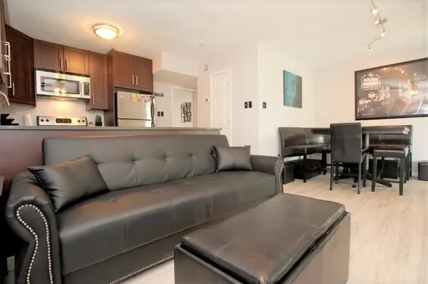 a living room with furniture kitchen view and a window