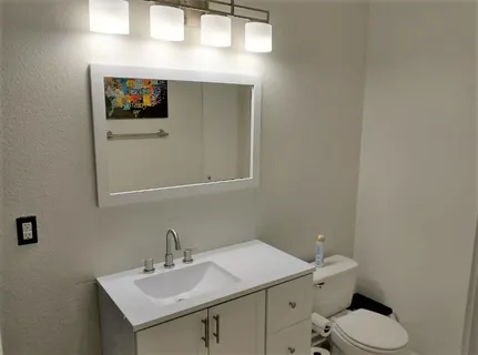a bathroom with a sink mirror and toilet