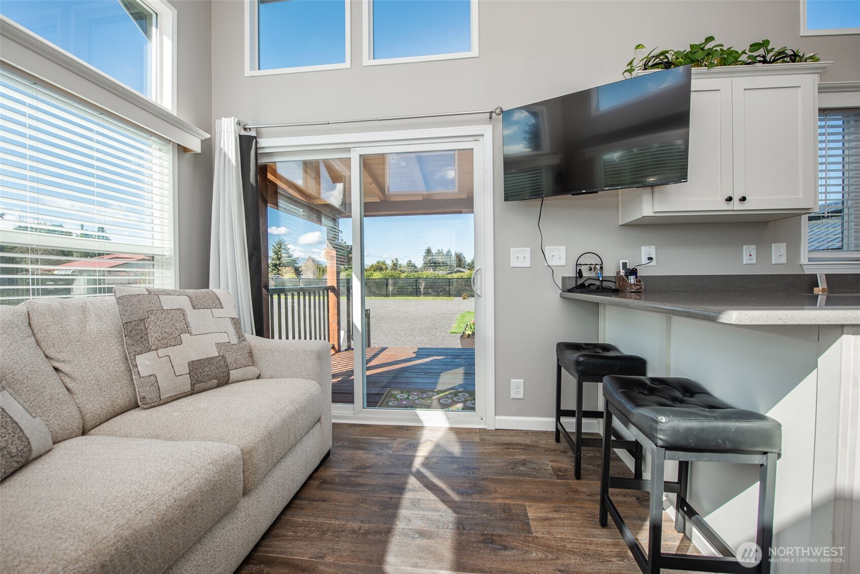 82 Williamson Road Sequim, WA 98382 - Photo 9 of 40 a living room with furniture a flat screen tv and floor to ceiling window