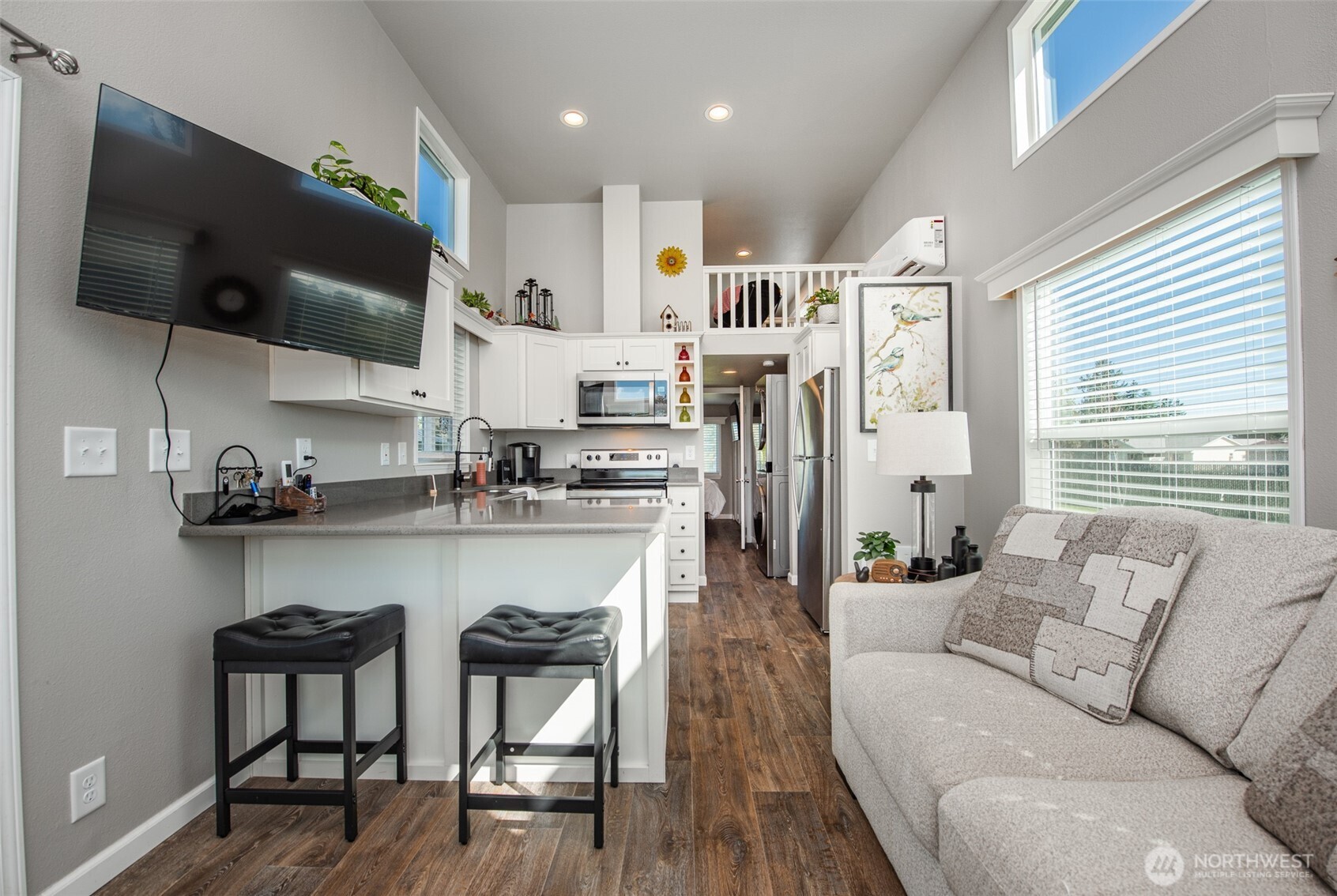 82 Williamson Road Sequim, WA 98382 - Photo 10 of 40 a living room with stainless steel appliances kitchen island granite countertop a couch a flat screen tv and a large window
