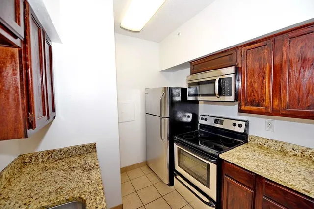 a kitchen with stainless steel appliances granite countertop a refrigerator and a stove top oven