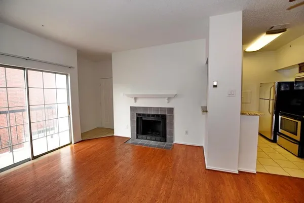 a view of empty room with wooden floor and fireplace