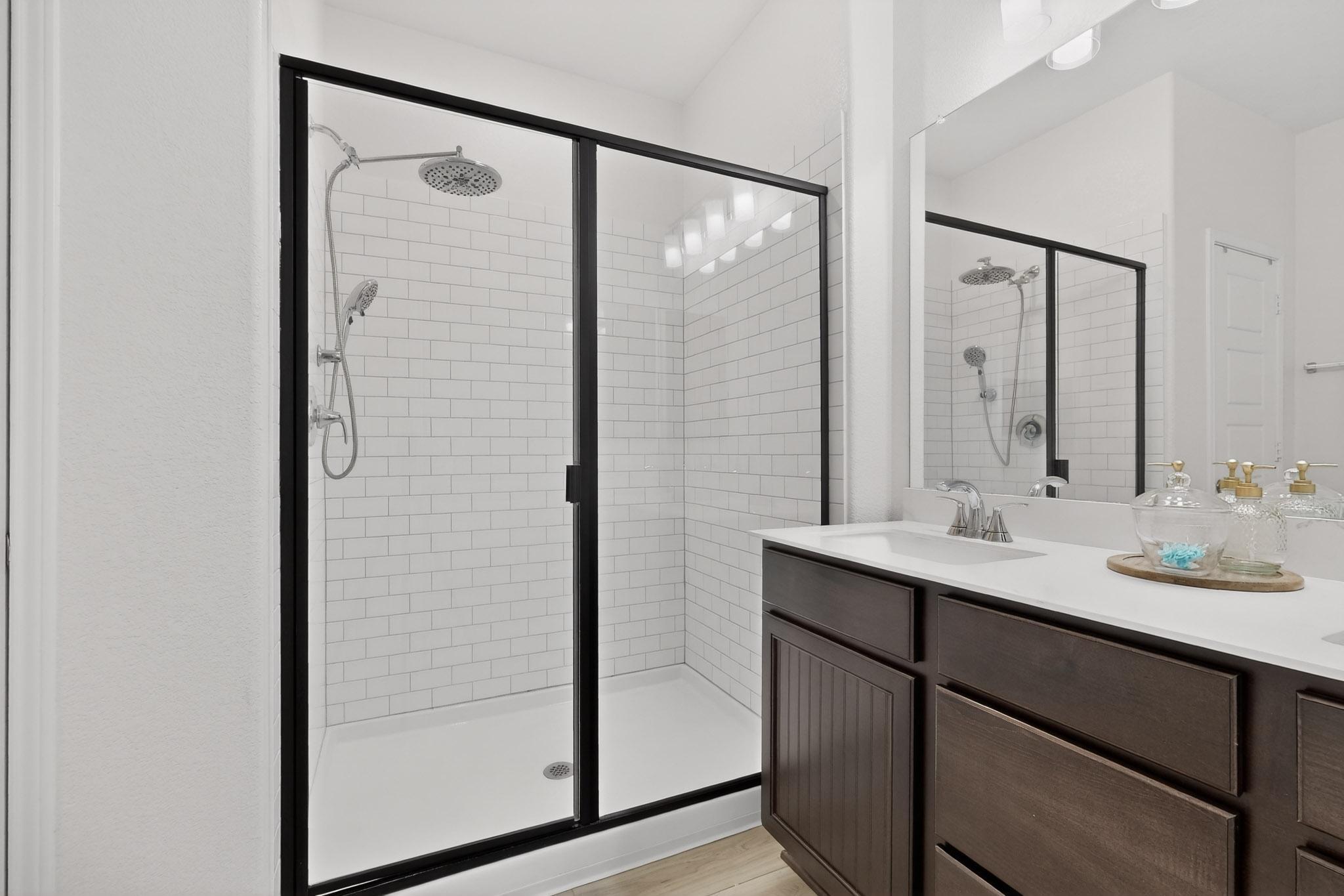 14513 Booted Eagle Pass Elgin, TX 78621 - Photo 21 of 33 Well-designed primary bath with dual sinks, generous storage, and a spacious walk-in shower with tile surround.