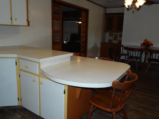 a kitchen with stainless steel appliances a table and chairs