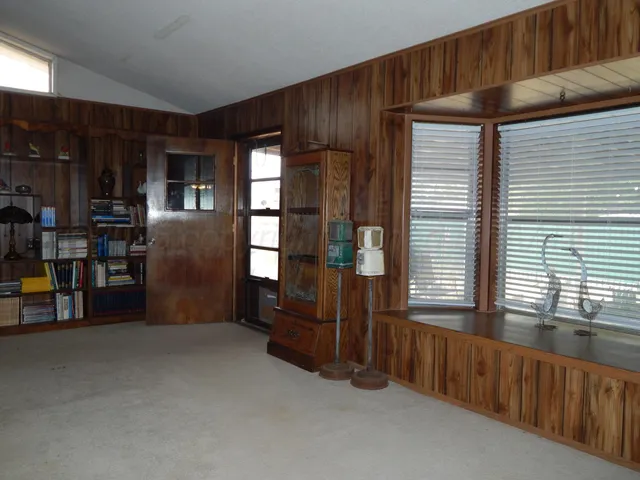 a view of an empty room with furniture and windows