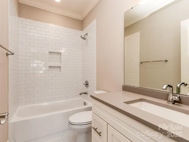 a bathroom with a sink a toilet a mirror a bathtub and shower