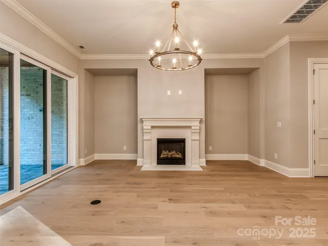 wooden floor fireplace and windows in an empty room