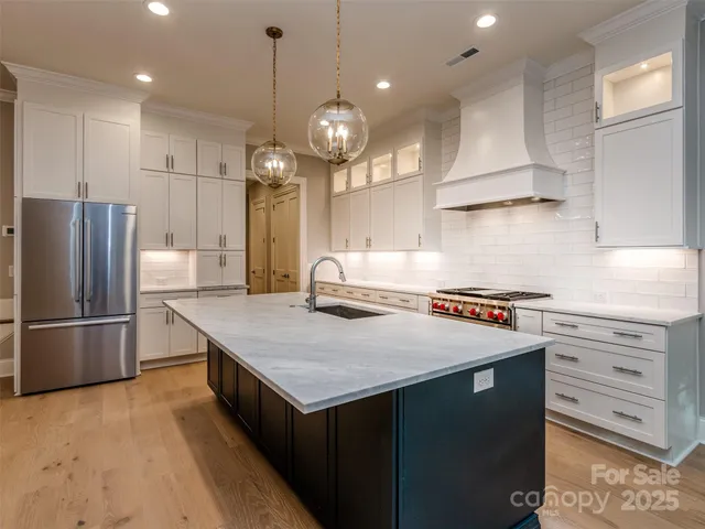 a kitchen with a refrigerator a sink and wooden floor