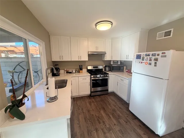 a kitchen with a refrigerator a stove top oven and a sink