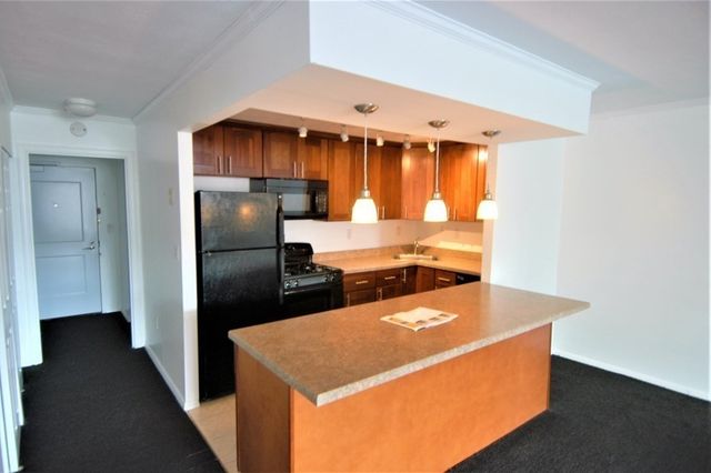 a kitchen with a refrigerator and a stove top oven