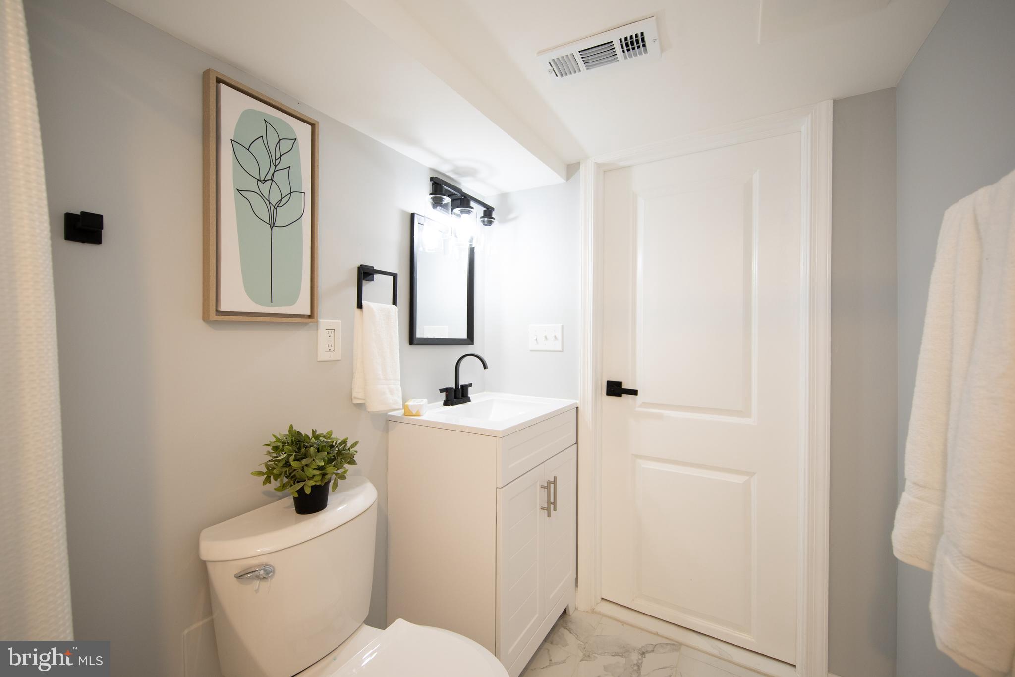 416 Dunkirk Road Baltimore, MD 21212 - Photo 28 of 33 a bathroom with a toilet a sink and mirror