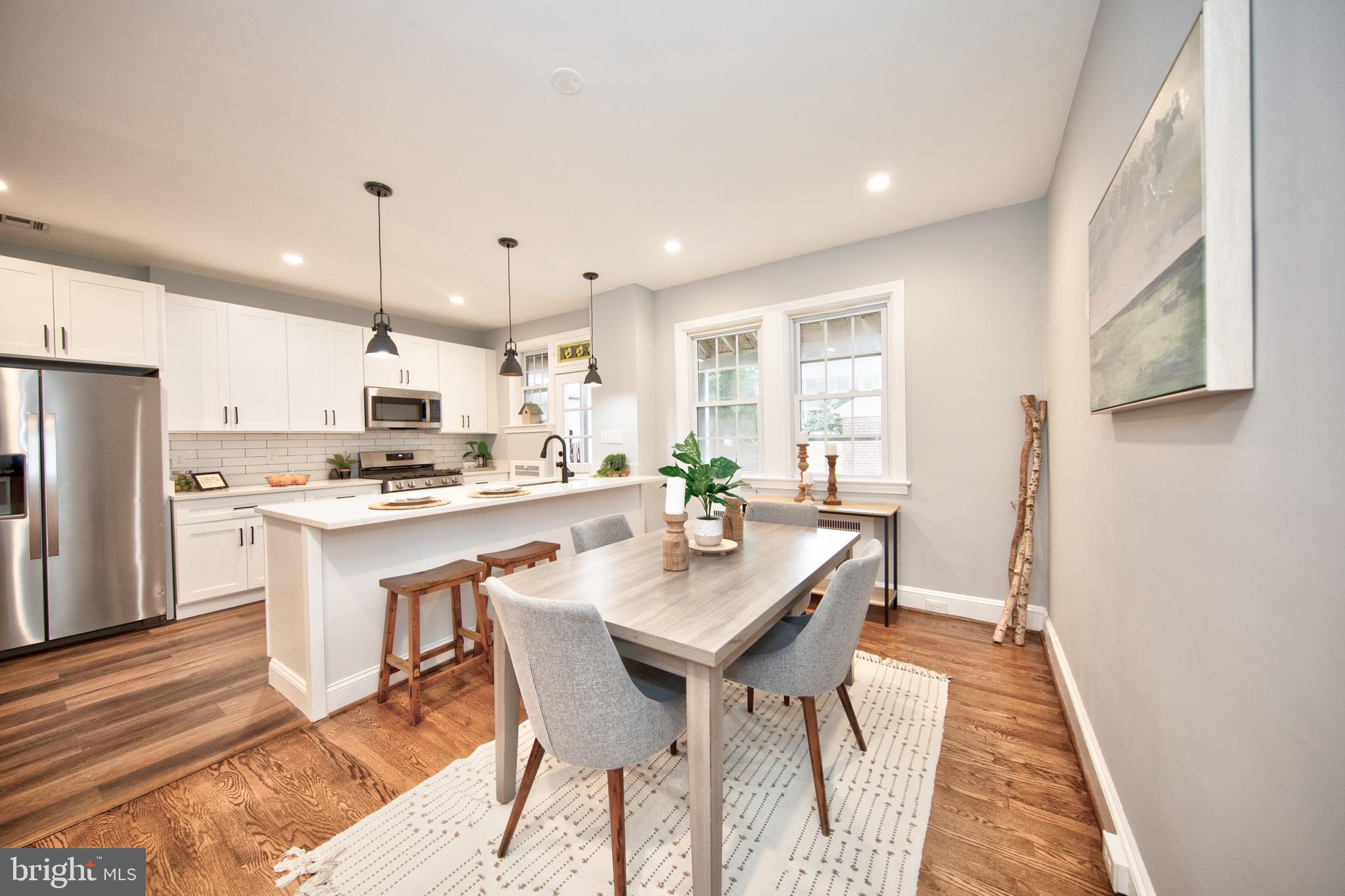 416 Dunkirk Road Baltimore, MD 21212 - Photo 8 of 33 a kitchen with stainless steel appliances kitchen island granite countertop a refrigerator a sink a stove a dining table and chairs