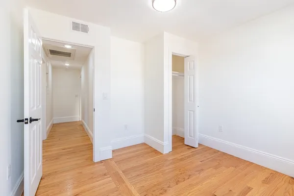 a view of empty room with wooden floor