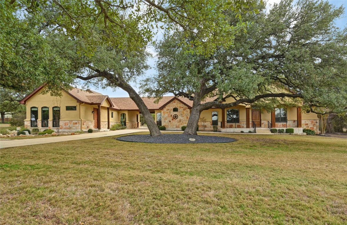 351 Hawthorne Loop Driftwood, TX 78619 - Photo 1 of 39 a front view of a house with a garden and trees