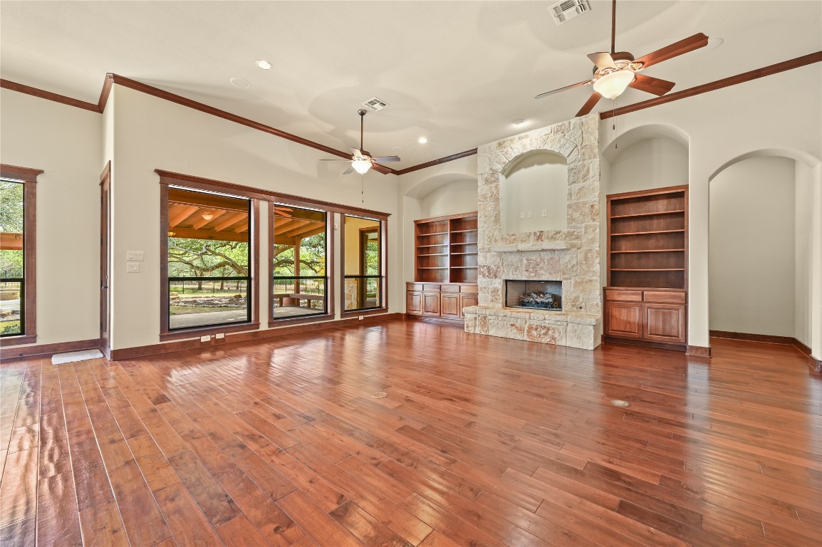 351 Hawthorne Loop Driftwood, TX 78619 - Photo 12 of 39 a view of an empty room with wooden floor fireplace and a window