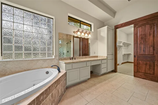 a spacious bathroom with a double vanity sink a large mirror and a shower