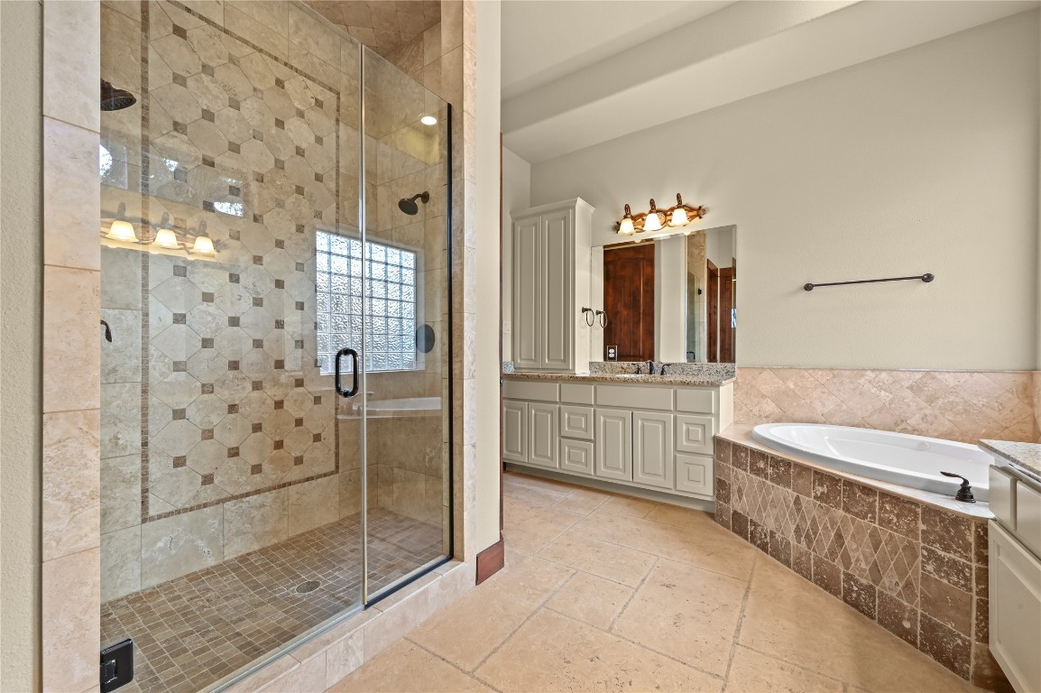 351 Hawthorne Loop Driftwood, TX 78619 - Photo 19 of 39 a spacious bathroom with a double vanity sink a large mirror and a shower