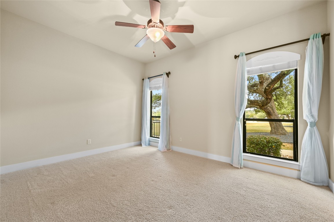 351 Hawthorne Loop Driftwood, TX 78619 - Photo 21 of 39 an empty room with windows and fan