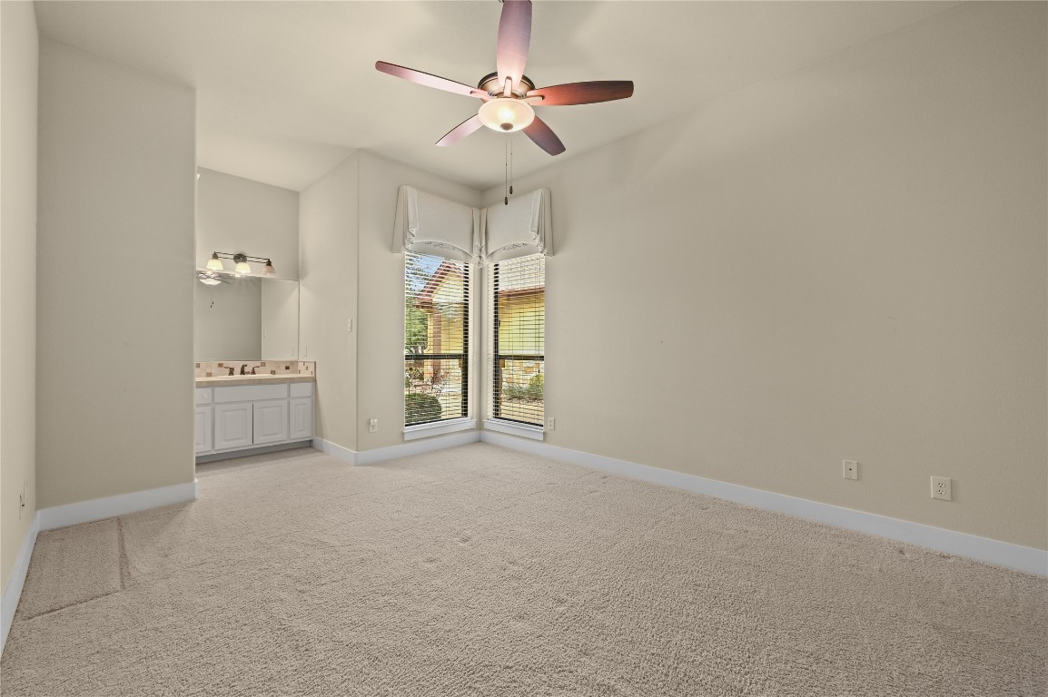 351 Hawthorne Loop Driftwood, TX 78619 - Photo 23 of 39 an empty room with a ceiling fan and a bathroom