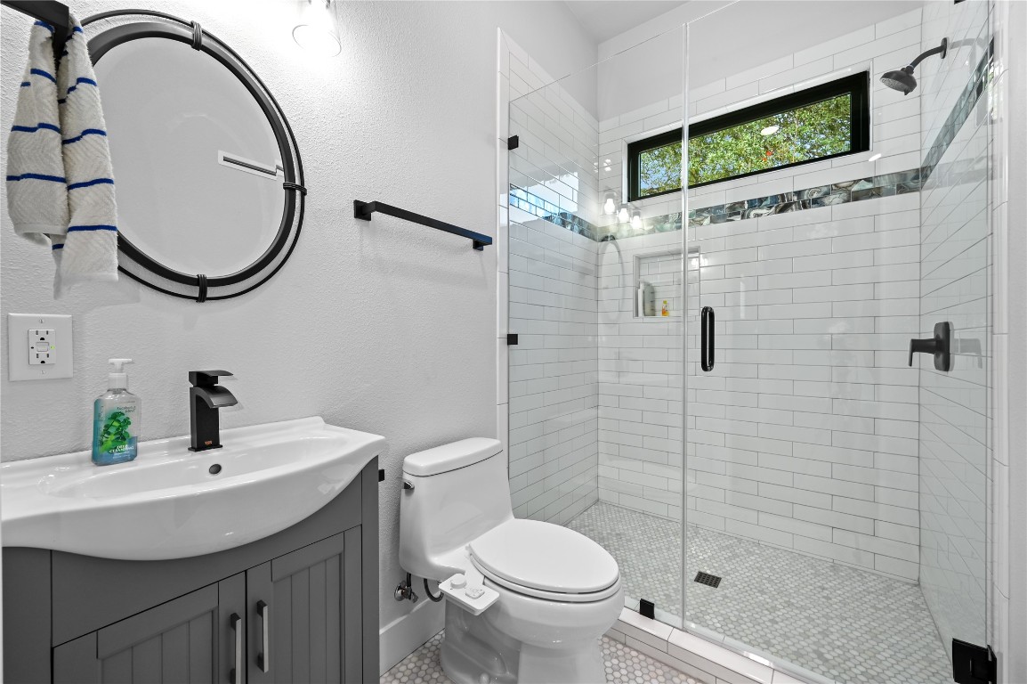 351 Hawthorne Loop Driftwood, TX 78619 - Photo 30 of 39 a bathroom with a sink a toilet and a mirror