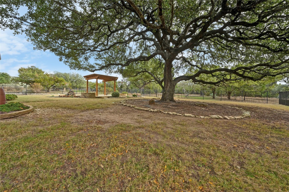 351 Hawthorne Loop Driftwood, TX 78619 - Photo 38 of 39 a backyard of a house with barbeque oven and large trees