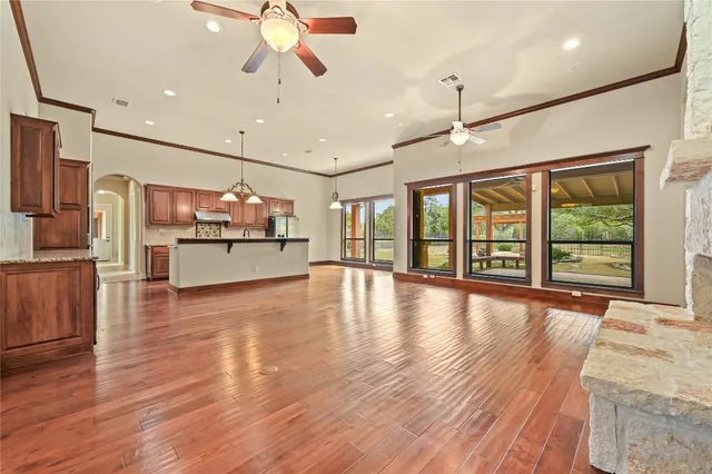a view of a livingroom with furniture a ceiling fan and wooden floor