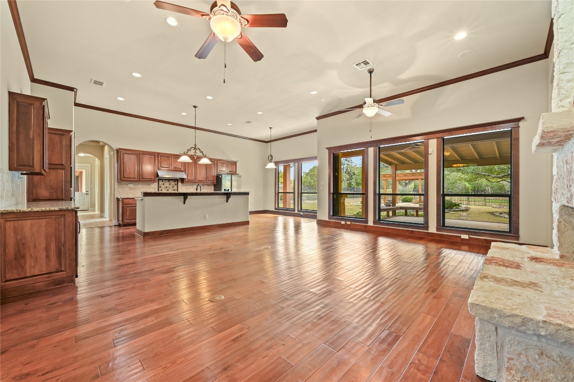 351 Hawthorne Loop Driftwood, TX 78619 - Photo 10 of 39 a view of a livingroom with furniture wooden floor a ceiling fan and windows