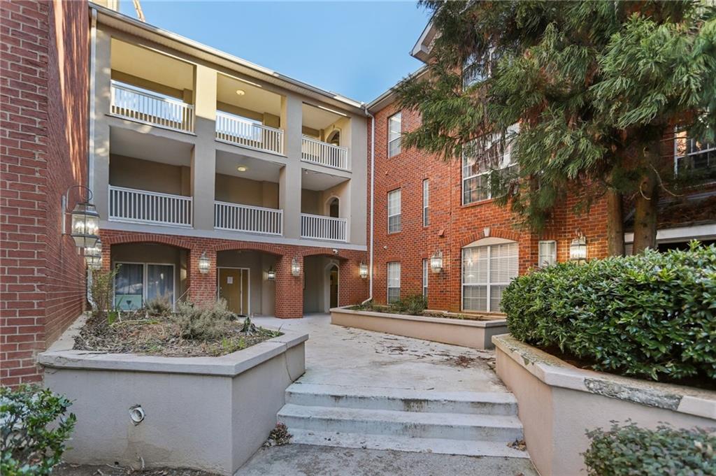 5641 Roswell Road, Unit 201 Atlanta, GA 30342 - Photo 12 of 14 a front view of a residential apartment building with a yard