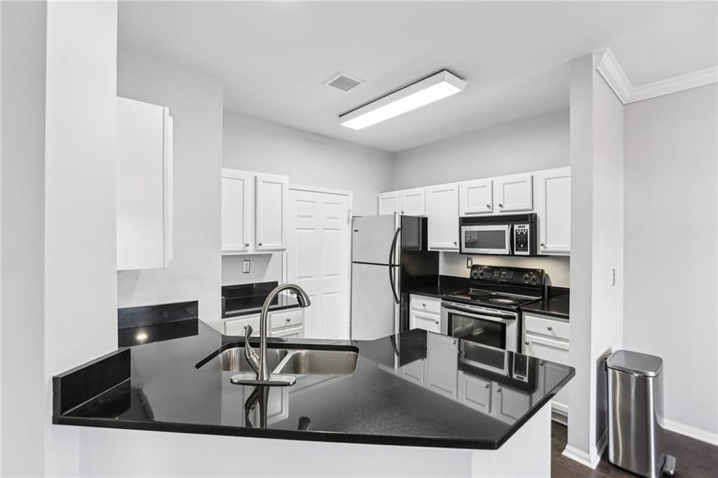 5641 Roswell Road, Unit 201 Atlanta, GA 30342 - Photo 2 of 14 a kitchen with stainless steel appliances granite countertop a sink a stove and a microwave