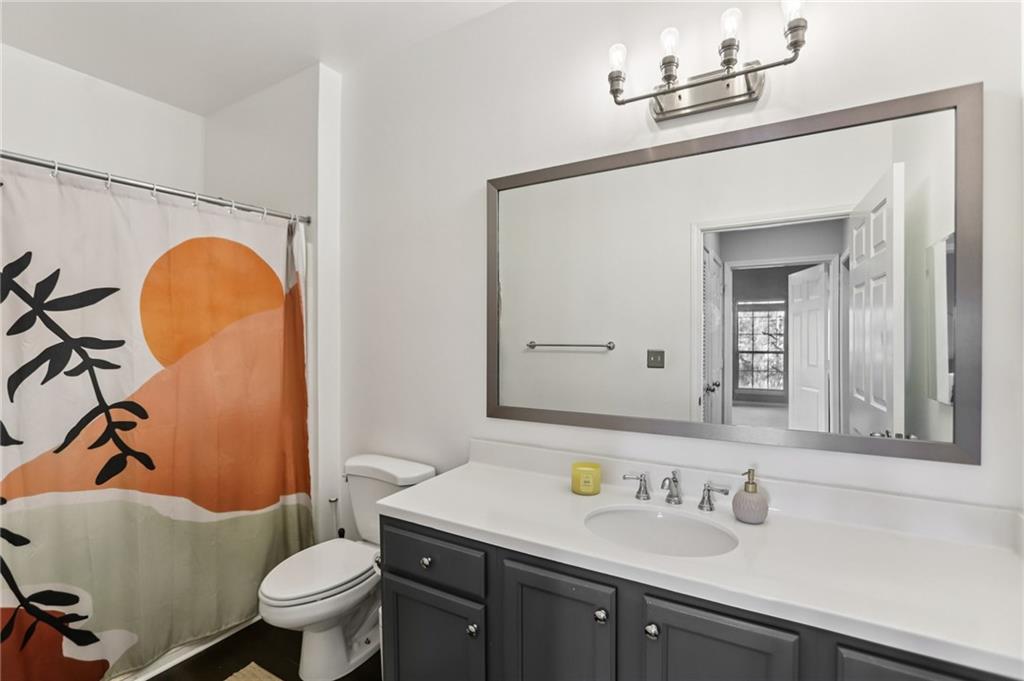 5641 Roswell Road, Unit 201 Atlanta, GA 30342 - Photo 5 of 14 a bathroom with a granite countertop toilet sink and mirror