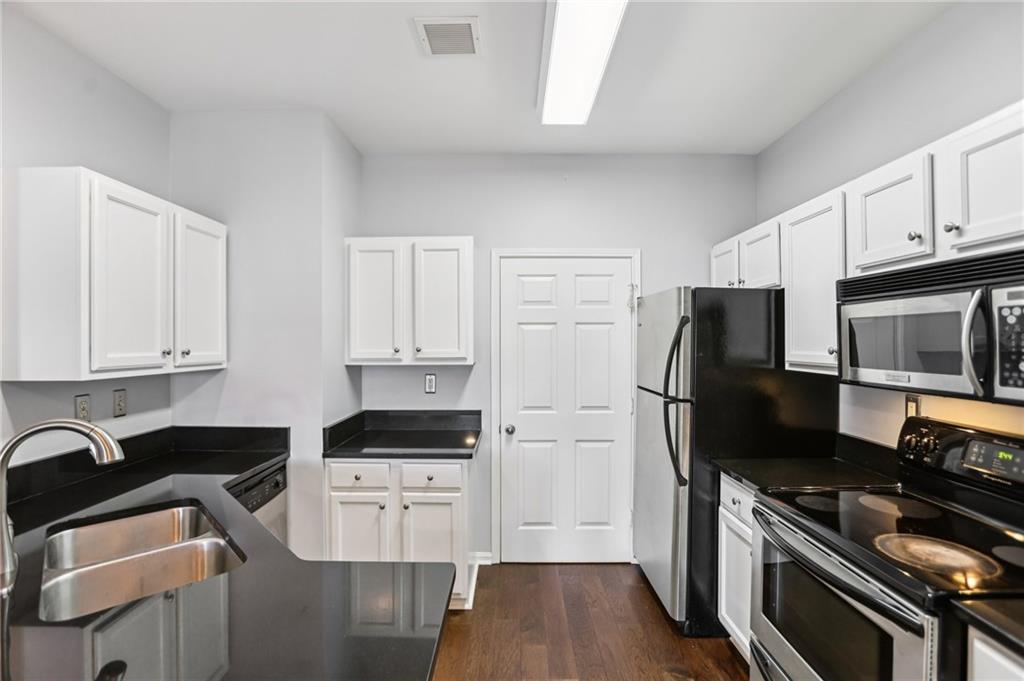 5641 Roswell Road, Unit 201 Atlanta, GA 30342 - Photo 9 of 14 a kitchen with stainless steel appliances a stove a sink a refrigerator and cabinets