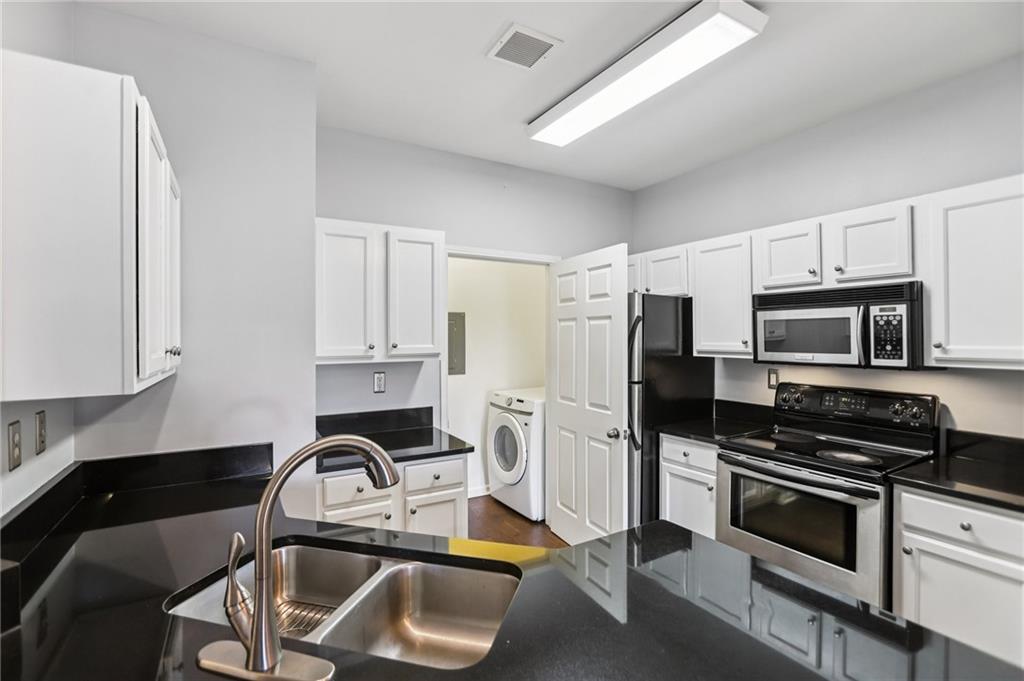 5641 Roswell Road, Unit 201 Atlanta, GA 30342 - Photo 10 of 14 a kitchen with stainless steel appliances a stove a sink a refrigerator white cabinets and a microwave