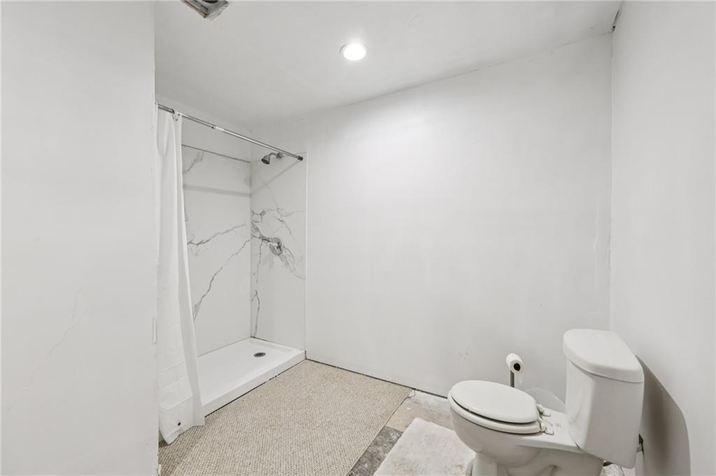 436 Lancelot Trail McDonough, GA 30252 - Photo 35 of 49 a bathroom with a granite countertop toilet and a shower