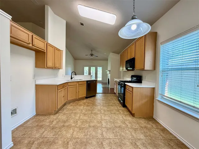 a kitchen with stainless steel appliances granite countertop a sink a stove top oven a counter space and cabinets