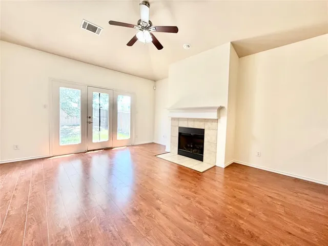 a view of empty room with wooden floor and fireplace