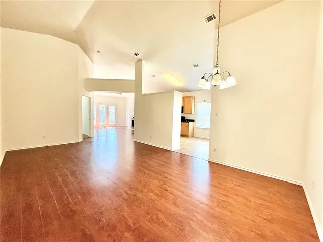 a view of an empty room and kitchen view