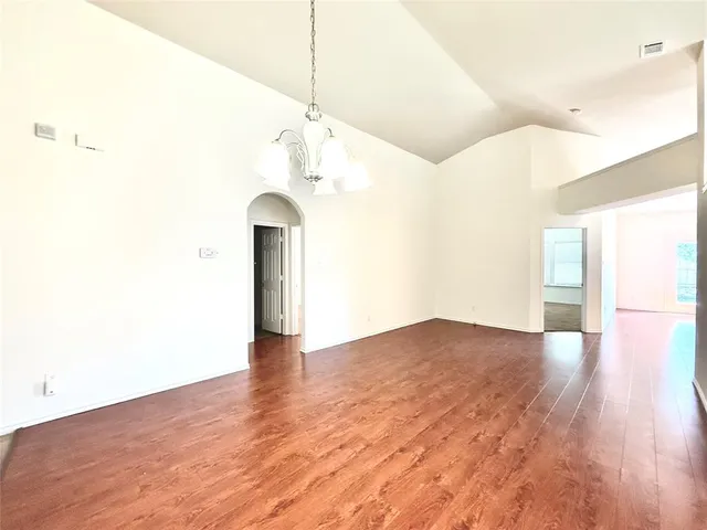 a view of a room with wooden floor and a ceiling fan