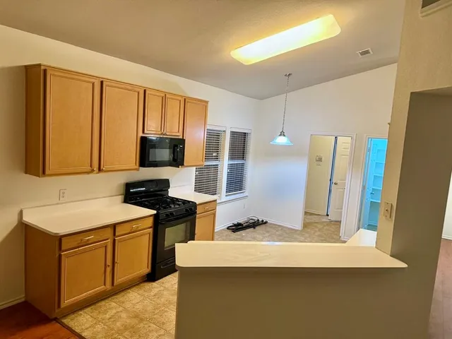 a kitchen with stainless steel appliances a stove refrigerator sink and microwave