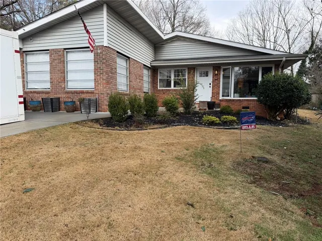 a view of a house with backyard and sitting area