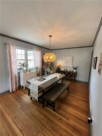 a living room with a table chairs and a wooden floor