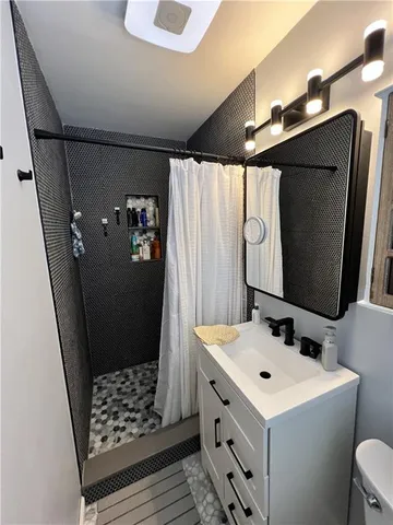 a bathroom with a sink and mirror with bathtub
