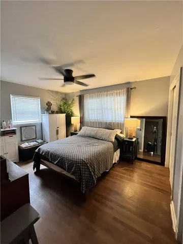 a spacious bedroom with a bed and a ceiling fan
