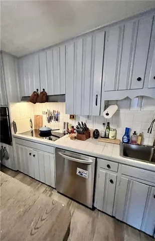 a kitchen with cabinets a sink and white appliances