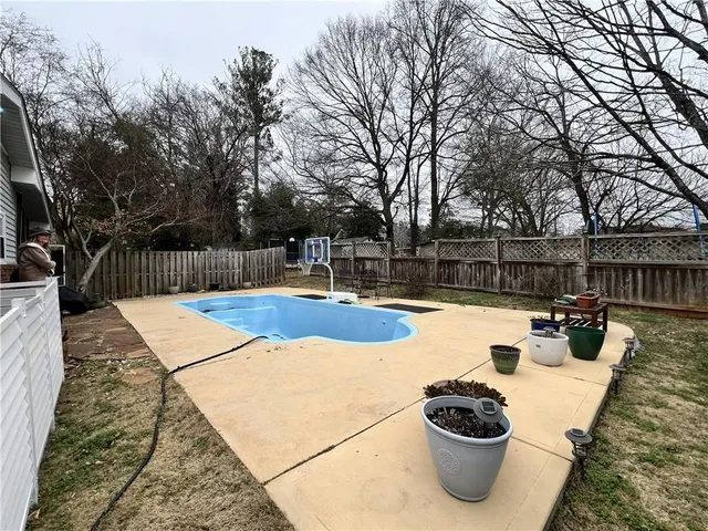 a view of a swimming pool with couches and potted plants