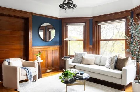 a living room with furniture a chandelier and a large window