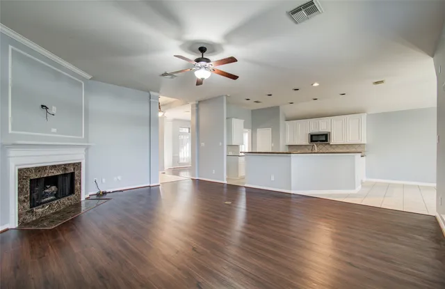 a view of an empty room with window and wooden floor