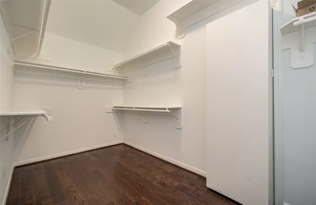 a view of room with wooden floor and white walls
