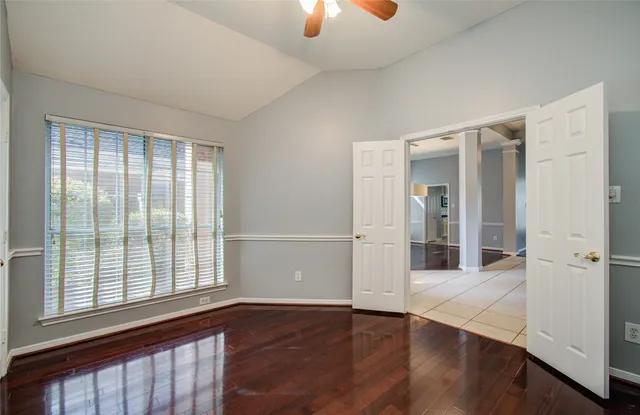 an empty room with wooden floor and chandelier