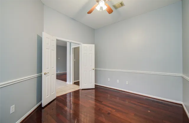 a view of an empty room with a window and wooden floor
