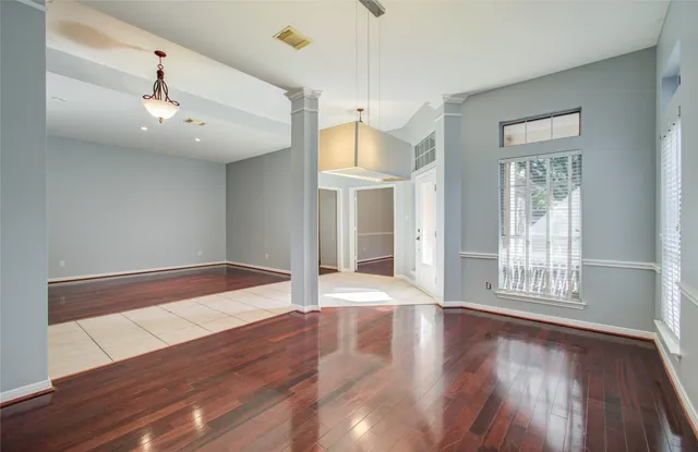 a view of a hallway with wooden floor and chandelier